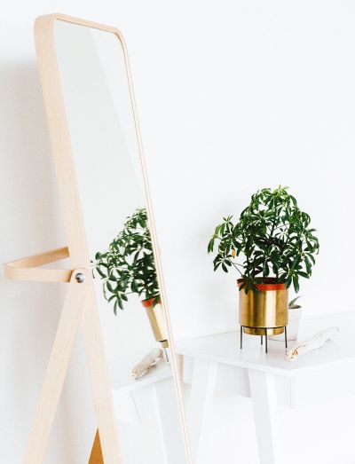 Standspiegel mit weißem Tischchen und grüner Pflanze