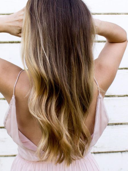 Frau mit langen Haaren und Sommerkleid, von hinten