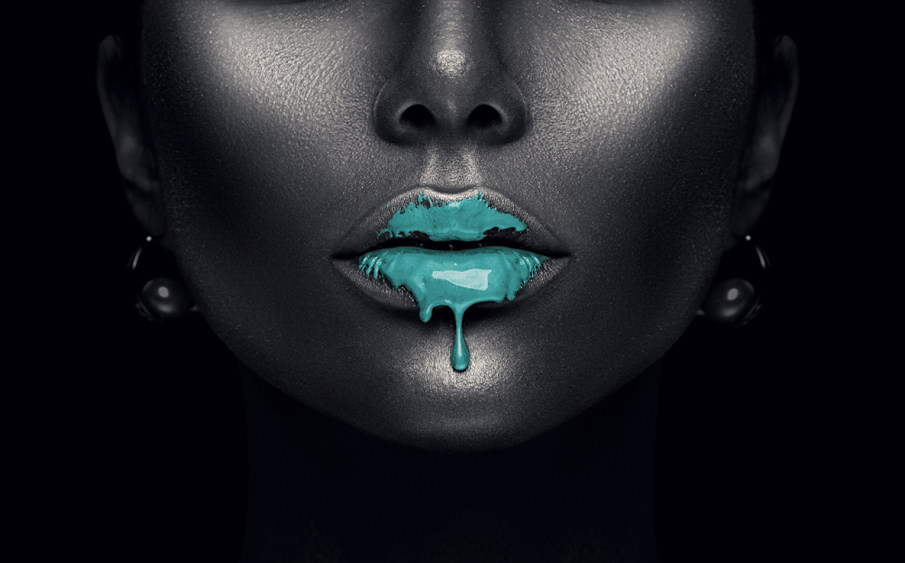 Frauengesicht, schwarz eingefärbt, auf dem Mund ein petrolfarbener Fleck